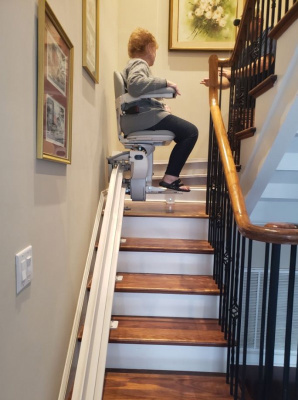 woman rides on new stairlift in home in Hanahan SC installed by Lifeway Mobility