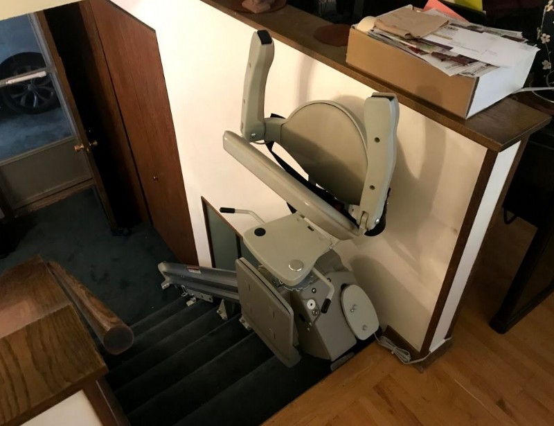 newly-installed-stairlift-in-Minnesota-home-with-arms-seat-and-footrest-folded-up-at-top-landing.JPG